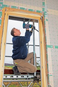 carpenter mounting a new window
